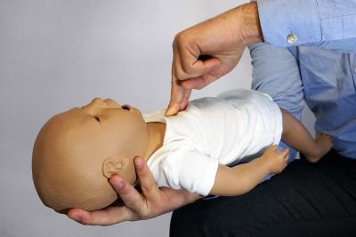 performing cpr on a simulation mannequin baby dummy during medical training