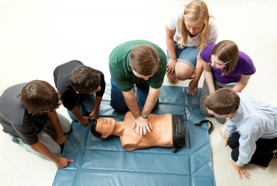 group of teenagers learing CPR in school